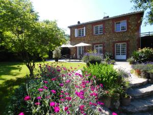 un giardino di fronte a una casa di mattoni con fiori rosa di Bed & Breakfast La Clepsydre a Fontenay-aux-Roses
