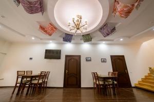 a room with tables and chairs and a chandelier at Caravan Hotel in Khiva