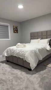 a bedroom with a large bed with white sheets at 3 Bedroom Single Family Home in Edmonton