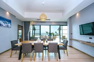 una sala da pranzo con tavolo, sedie e TV di C&N Kho Khao Beach Resort - SHA Plus a Ko Kho Khao