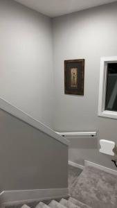 a white room with a staircase and a window at 3 Bedroom Single Family Home in Edmonton