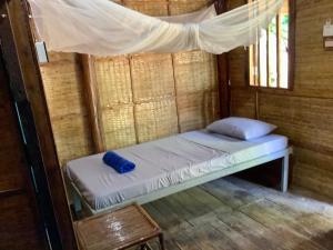 a bed in a room with a mosquito net at CocoHuts in Koh Rong Sanloem