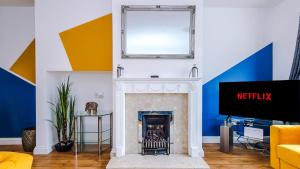 uma sala de estar com lareira e espelho em Newhall Road - 4 Bedroom Chester Home - Parking em Wervin