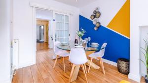 uma sala de jantar com uma mesa de vidro e cadeiras brancas em Newhall Road - 4 Bedroom Chester Home - Parking em Wervin