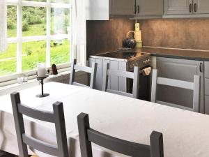 een keuken met een tafel en stoelen en een fornuis bij Five-Bedroom Holiday home in Masfjordnes in Masfjorden