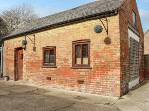 een bakstenen gebouw met twee ramen en een deur bij The Old Dairy in Herne Bay