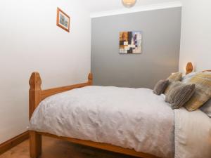 Schlafzimmer mit einem Bett mit weißer Bettwäsche und Kissen in der Unterkunft The Old Dairy in Herne Bay