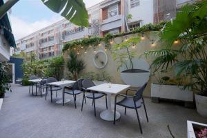 Papersun Hotel في تايبيه: صف من الطاولات والكراسي على فناء به نباتات