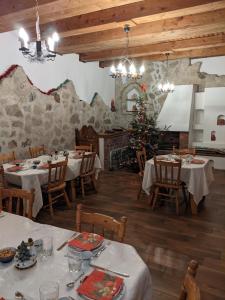 a restaurant with tables and chairs and a christmas tree at Cabana Serenade in Suceviţa