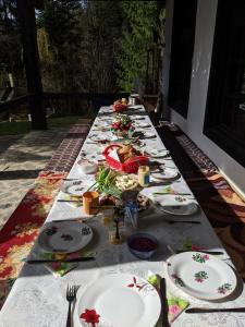 a long table with plates of food on it at Cabana Serenade in Suceviţa