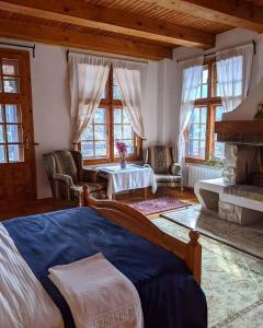 Schlafzimmer mit einem Bett, einem Tisch und Fenstern in der Unterkunft Cabana Serenade in Suceviţa