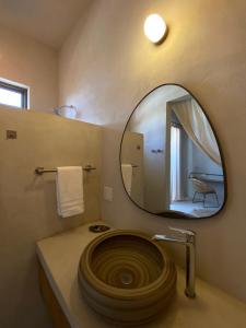 a bathroom with a large round mirror and a sink at The Mantarraya Outpost in La Paz