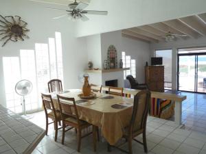 y sala de estar con mesa de comedor y sillas. en Casa Blanca frente a la playa, en Playa del Estero