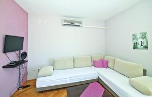 een woonkamer met een witte bank en roze kussens bij Apartments Hazi 1 - 150m from sea in Trogir