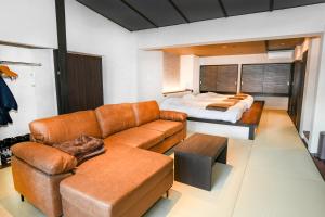 uma sala de estar com um sofá e uma cama em Sozankyo em Aso