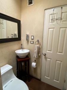 een badkamer met een wit toilet en een wastafel bij Casita Capri in Ciudad Juárez