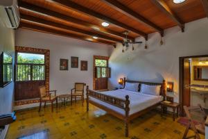 a bedroom with a bed and a table and chairs at My Village - Eco Rural Resort in Coimbatore
