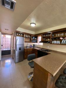 eine Küche mit einem Kühlschrank und Schränken aus Edelstahl in der Unterkunft Casita Capri in Ciudad Juárez