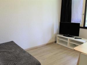 ヴァールにあるAppartement Vars, 2 pièces, 4 personnes - FR-1-330B-23のテレビ付きのスタンドとベッドが備わる客室です。