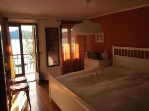 Un dormitorio con una cama grande y una ventana en Das alte Fischerhaus am See, en Oggebbio