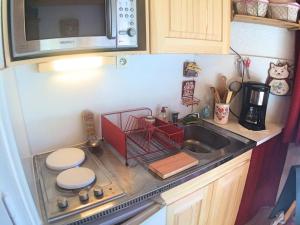 eine kleine Küche mit einer Spüle und einer Mikrowelle in der Unterkunft Appartement Vars, 1 pièce, 2 personnes - FR-1-330B-26 in Vars
