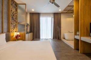 a bedroom with a large bed and a bath tub at Moon Sun Boutique Villa Hotel in Hue