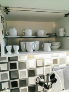 a shelf with plates and cups and dishes on it at 2 Bedrooms close Vyšehrad - Congress centrum in Prague