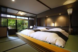 um quarto com 2 camas e almofadas brancas em Sozankyo em Aso