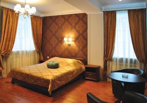 a bedroom with a bed and a table and curtains at Hotel Staraya Bashnya in Sarapul