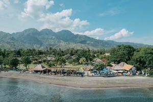 a beach with a resort and mountains in the background at Amertha Bali Villas in Pemuteran