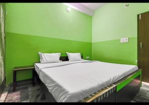 Habitación verde con cama grande en una habitación en Dev Guest House By WB Inn en Agra