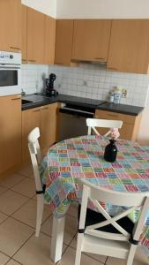 a kitchen with a table and two chairs and a kitchen with a stove at Appartement 90m2 op 70m van het strand. in Ostend