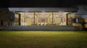 a building with a lot of windows and a grass field at Olive Resort & Villas in Khawāsa