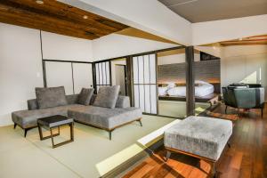 een woonkamer met een bank en een bed bij Sozankyo in Aso
