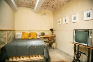 una camera con letto, scrivania e TV di 509 Accommodation a Città di Oaxaca