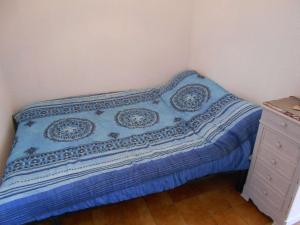 a bed with a blue blanket and a dresser in a bedroom at Appartement Port Camargue, 1 pièce, 4 personnes - FR-1-250-222 in Le Grau-du-Roi