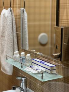 a bathroom with a sink and a shelf with a book at Hayot Hostel in Tashkent