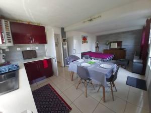 a kitchen and living room with a table and chairs at Appartement agréable, accès rapide. in Saint-Paul