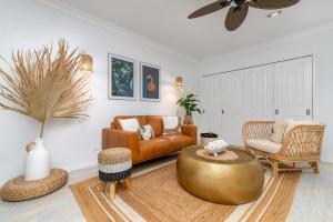 uma sala de estar com um sofá e uma mesa em Luxury Living In The Heart Of Town, King Bed, 2 Pools, Free WIFI And Undercover Parking em Port Douglas