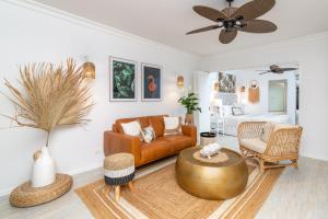 a living room with a couch and a table at Luxury Living In The Heart Of Town, King Bed, 2 Pools, Free WIFI And Undercover Parking in Port Douglas