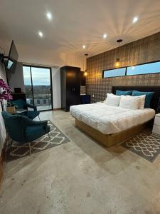 sypialnia z dużym łóżkiem i niebieskim krzesłem w obiekcie TEMEXKAL RESORT w mieście Ensenada