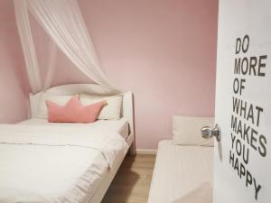 1 dormitorio con 2 camas y paredes de color rosa en The Secret Place en Melaka