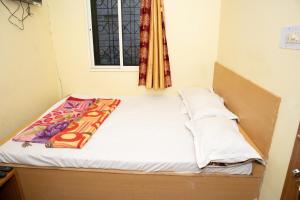 a small bed in a room with a window at Ganesh Residency in Cuttack