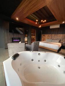 a large white bath tub in a room with a bed at TEMEXKAL RESORT in Ensenada