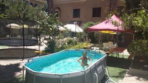 una persona seduta in una piscina in un cortile di Hotel Moderno ad Aritzo