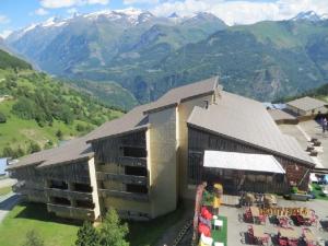 an aerial view of a building with mountains in the background at Appartement Auris, 2 pièces, 4 personnes - FR-1-297-65 in Auris