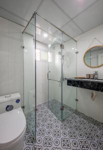 y baño con ducha de cristal y aseo. en Hanoi Sisters Boutique Hotel, en Hanói
