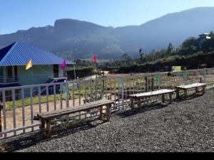 a row of benches sitting next to a fence at Aden Valley Tent Stay , kanthalloor in Kanthalloor