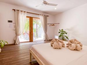a bedroom with a bed with two towels at Villa Kudì Maldives Guest House Thulusdhoo in Thulusdhoo