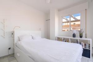 a white bedroom with a white bed and a window at 28 Rooftop apartment close to the beach Sabinillas in San Luis de Sabinillas +20 photos